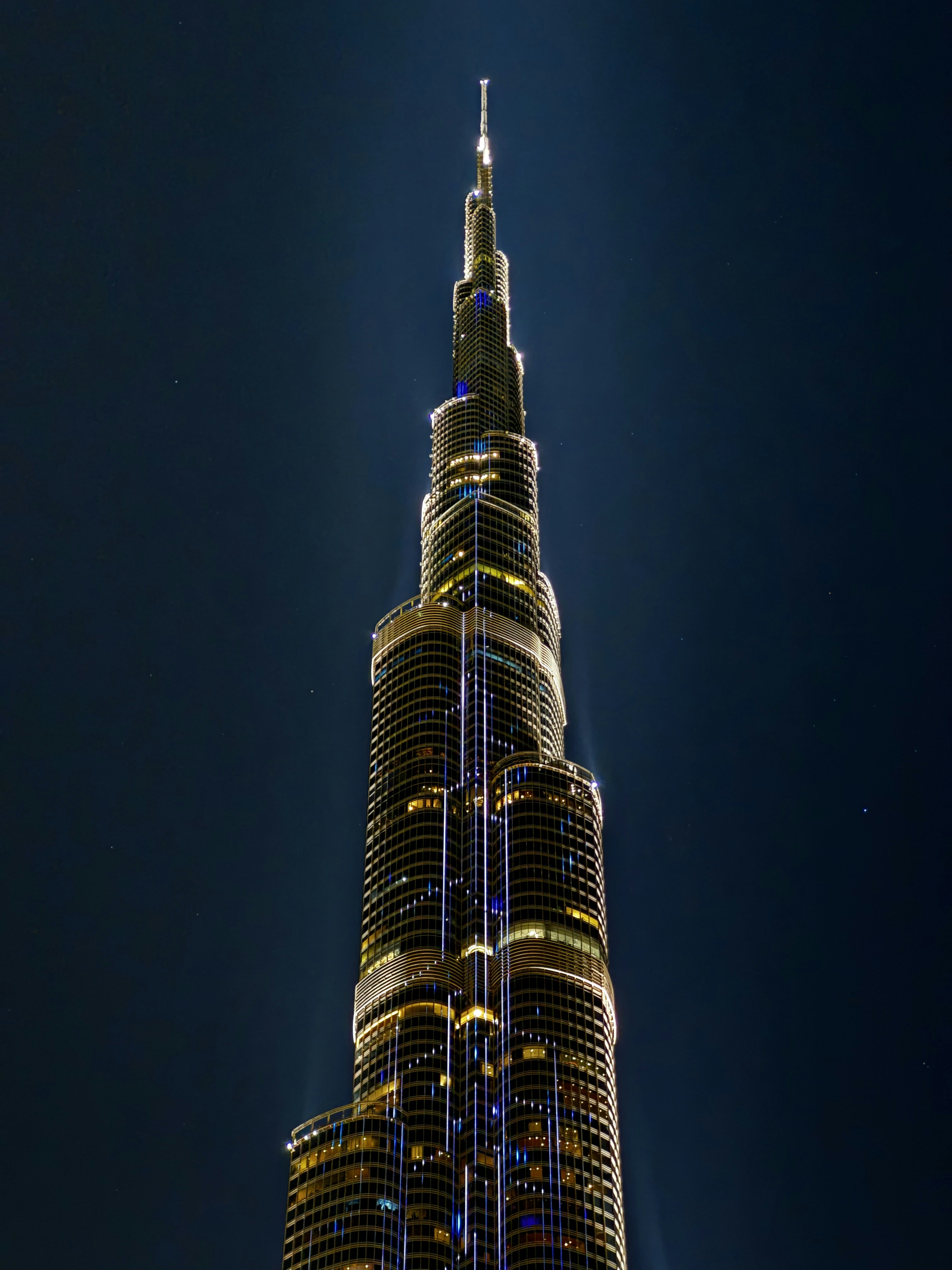 MENA regional bank headquarters illuminated at night, financial district Dubai, glass tower, dark atmospheric sky