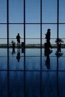 A couple of people that are standing in front of a window