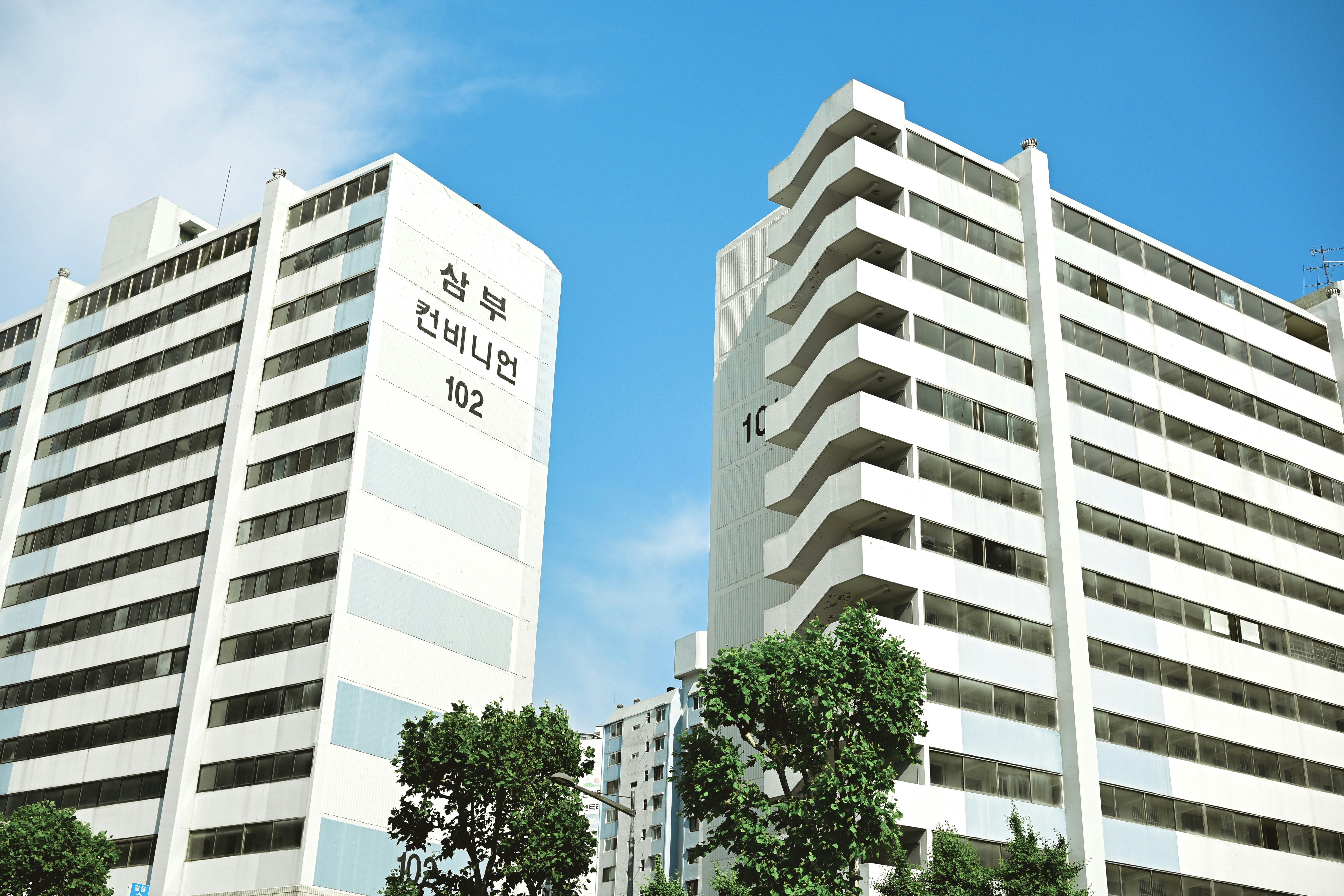 Two tall white buildings sitting next to each other