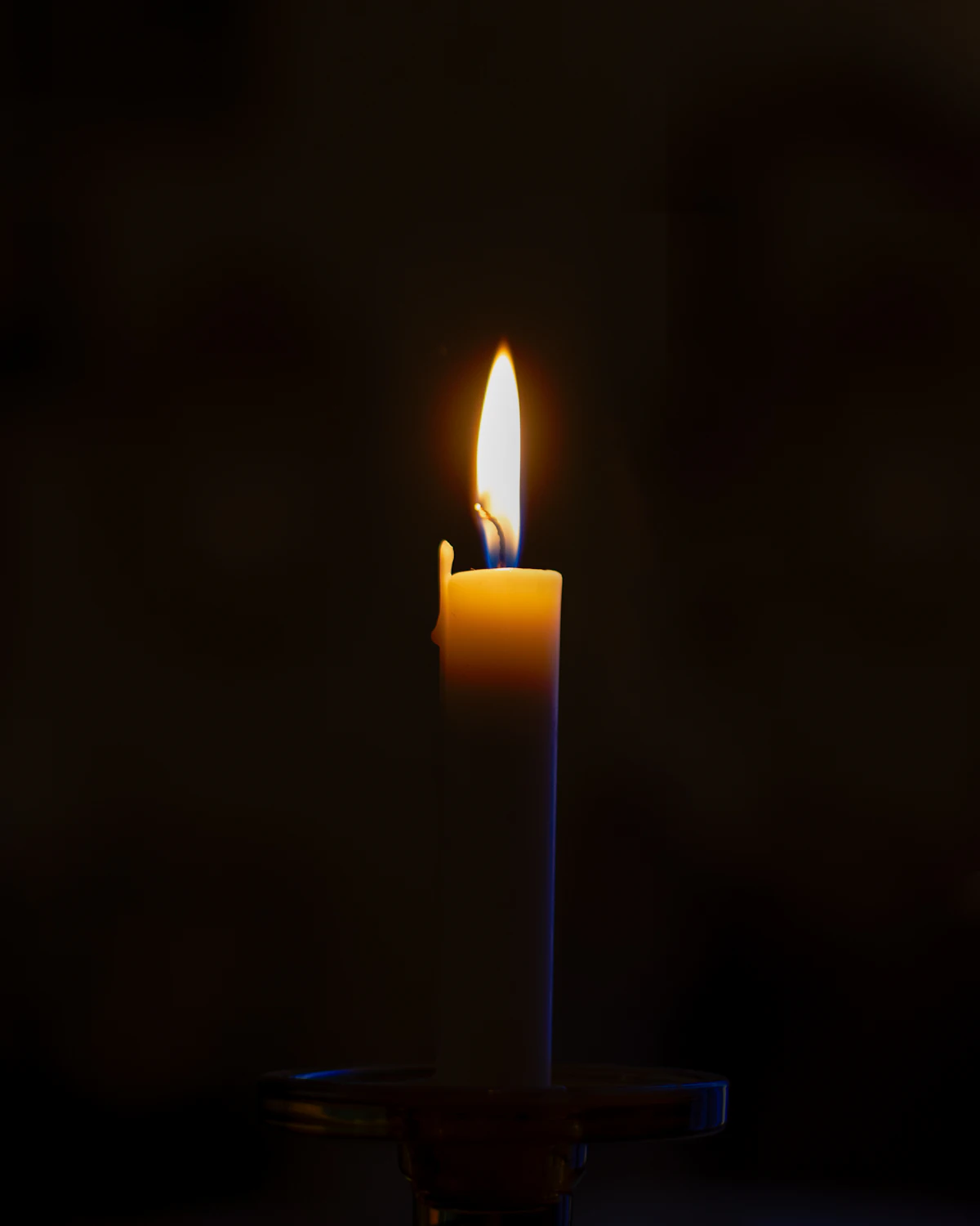 A single lit candle representing faith-based counseling and quiet prayerful reflection