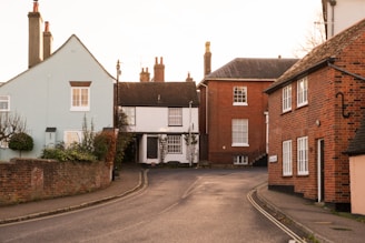 A street with houses and a truck parked on the side of the road