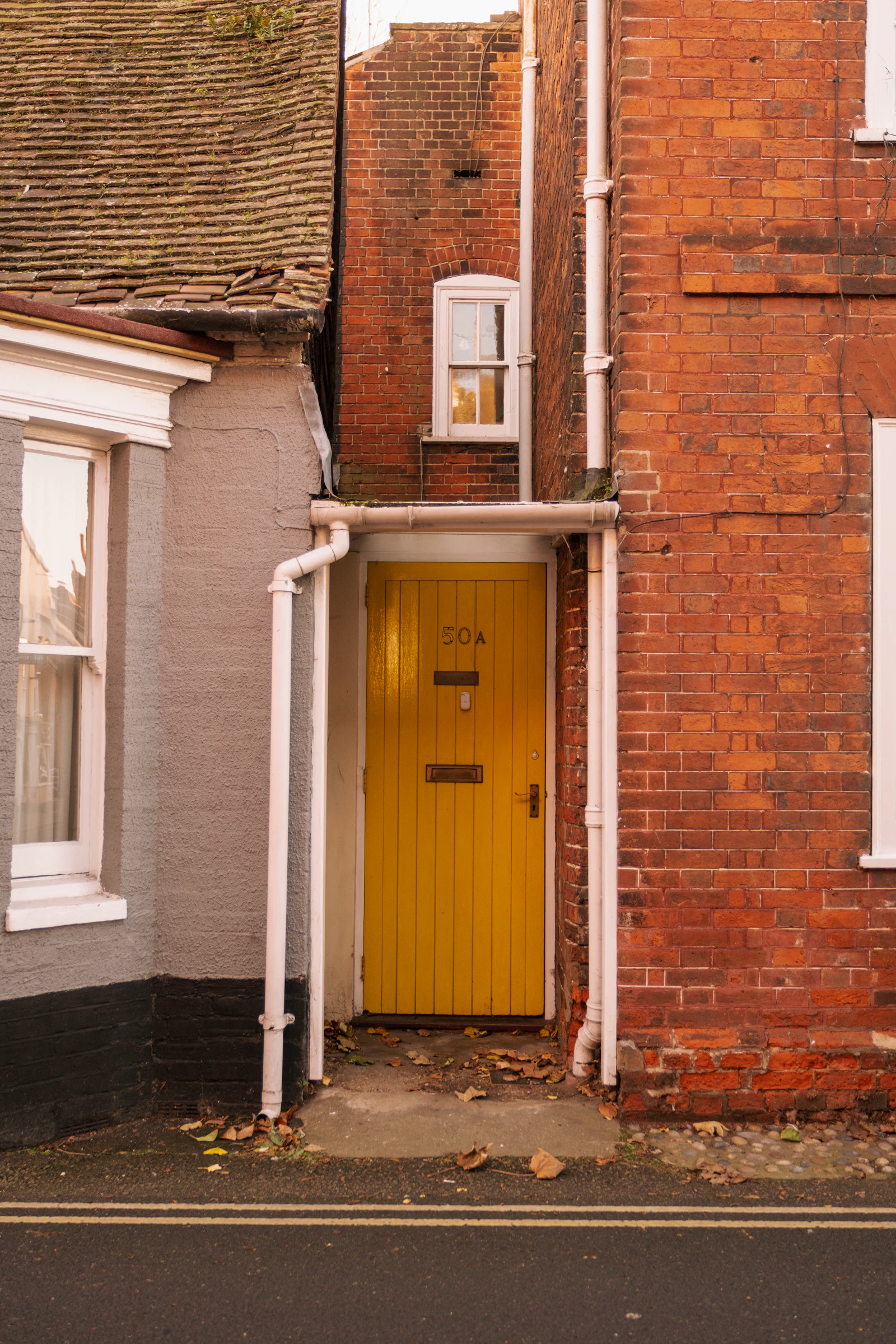 A yellow front door in a red brick wall