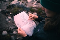 A woman holding a piece of paper with writing on it