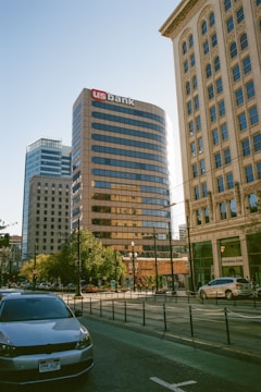 A car driving down a street next to tall buildings