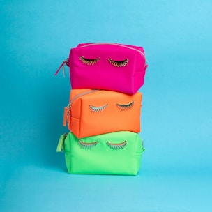 A stack of three colorful bags with eyelashes on them