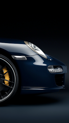 A blue sports car is shown in a dark room