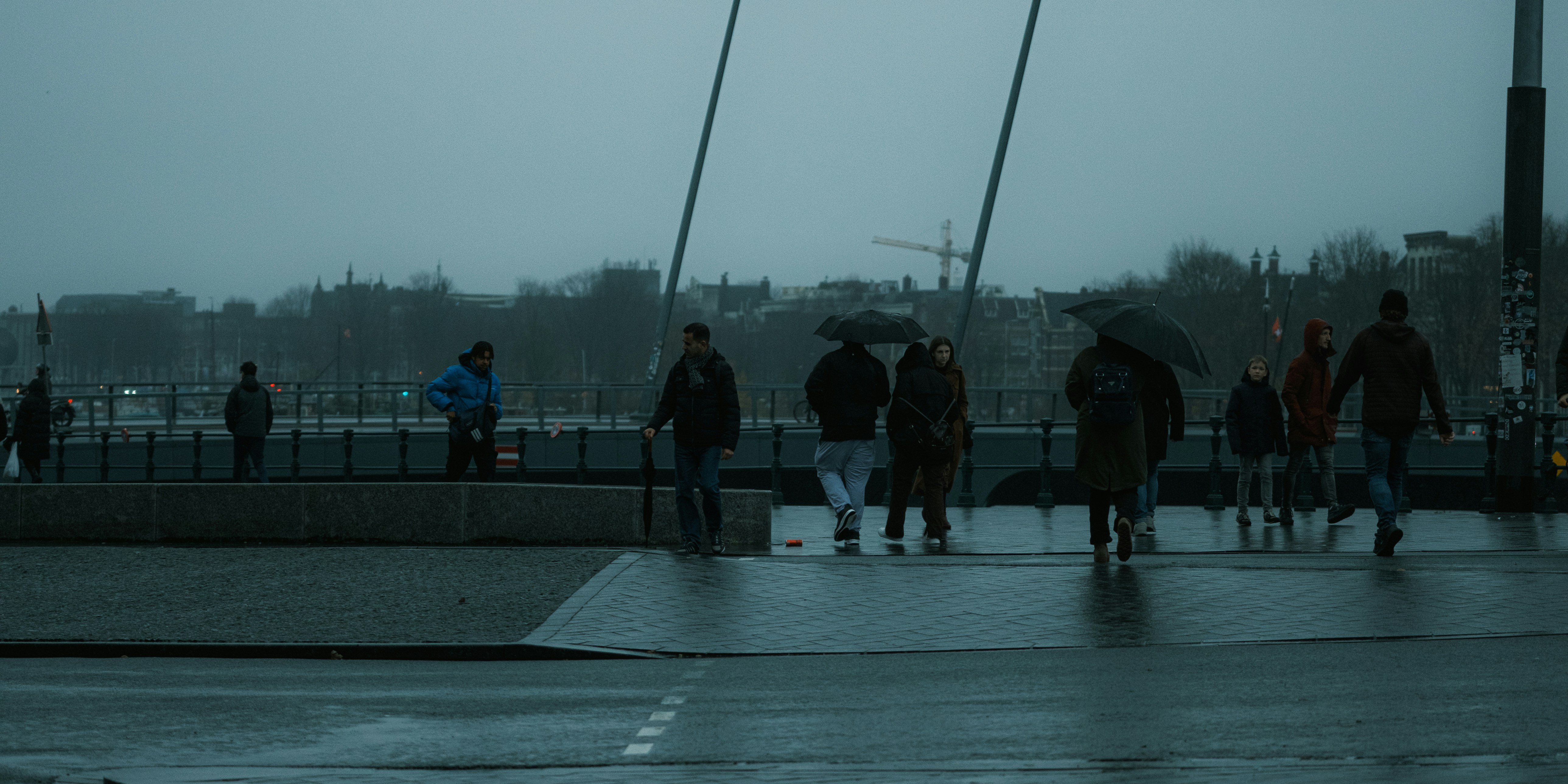 People enjoying light rain, maybe kids splashing in puddles or adults walking with umbrellas, looking happy and refreshed.