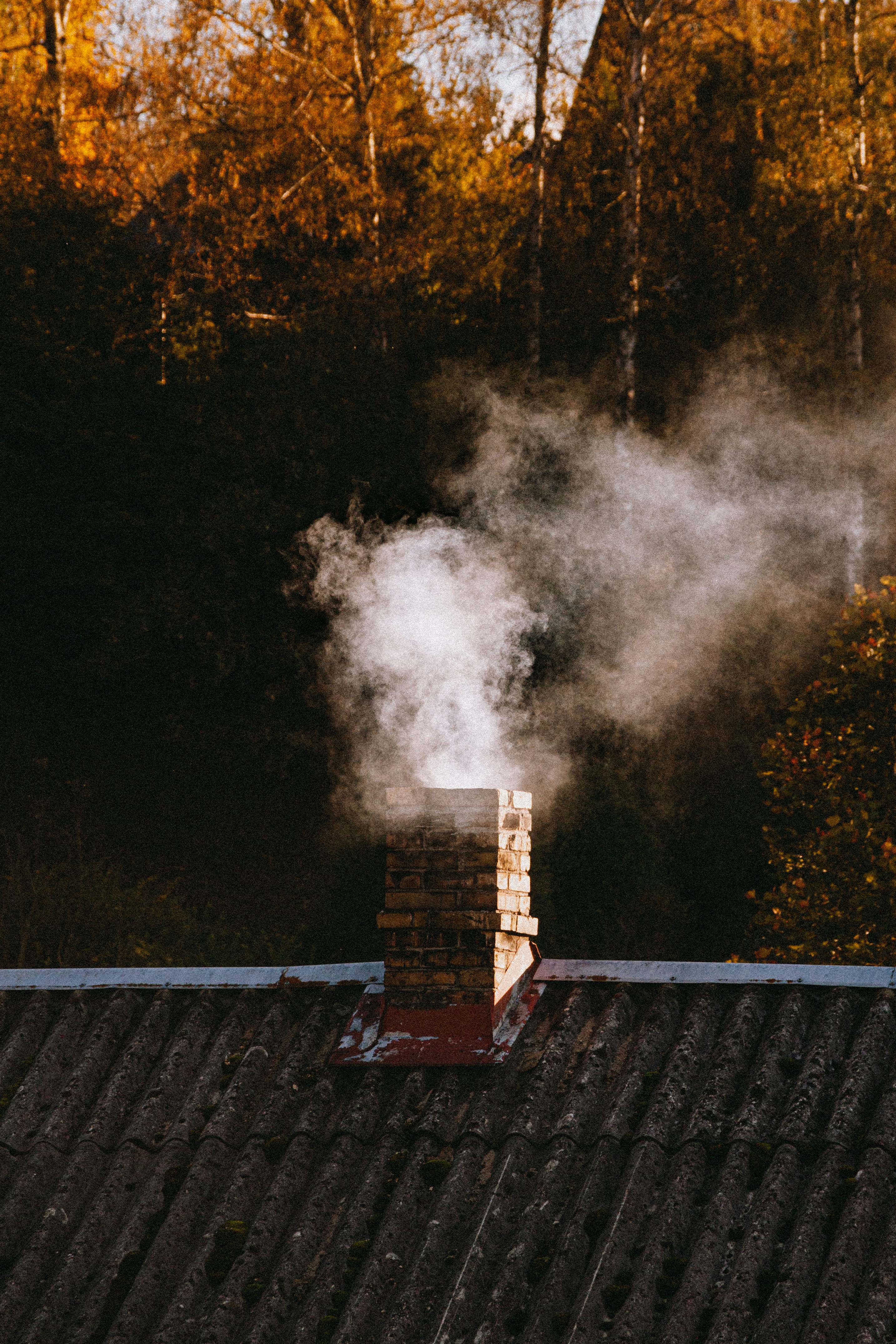 Smoke coming out of a chimney on top of a roof