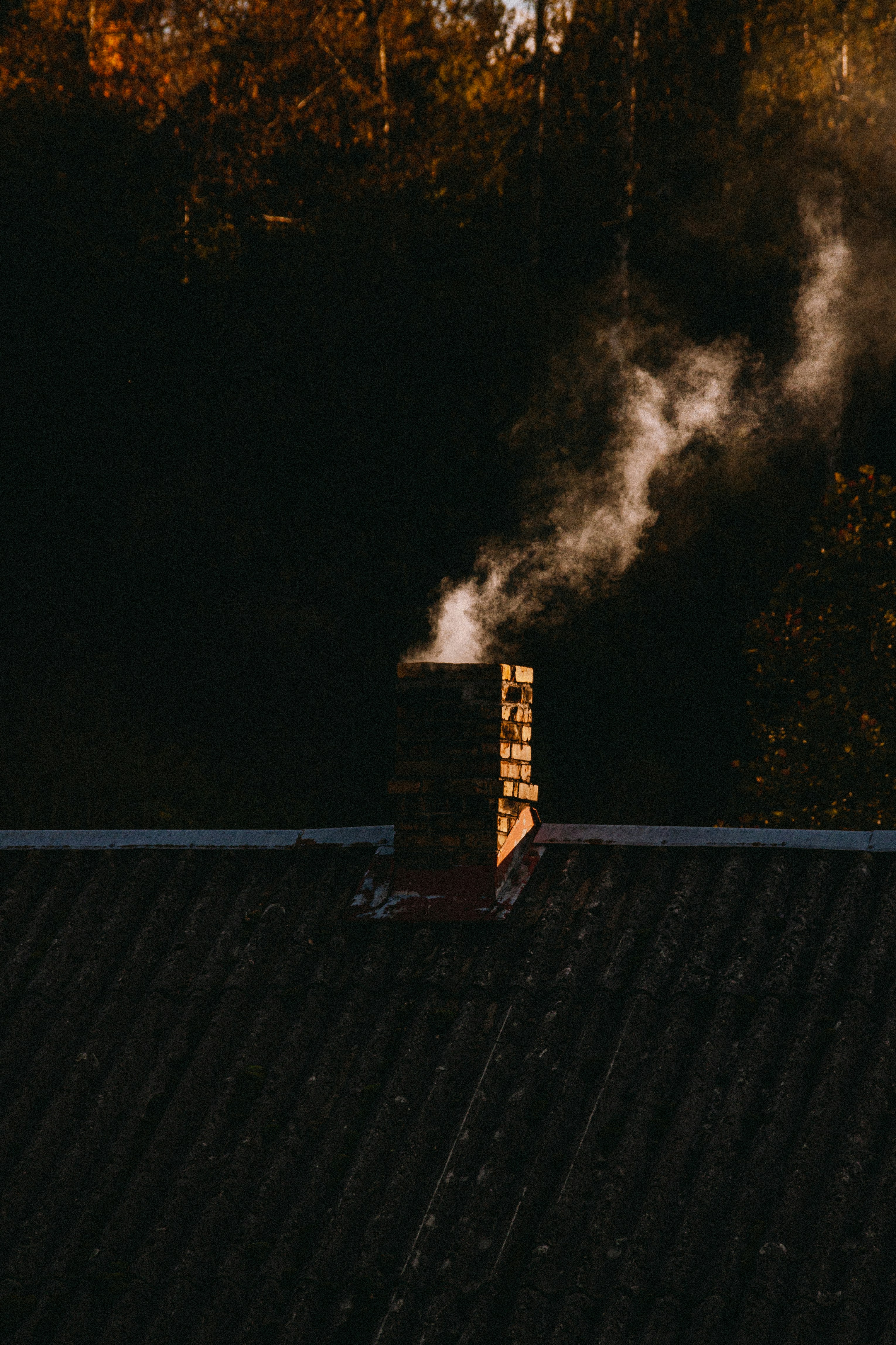 Smoke coming out of a chimney on top of a roof