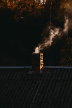 Smoke coming out of a chimney on top of a roof