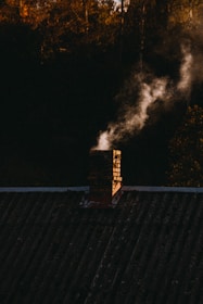 Smoke coming out of a chimney on top of a roof