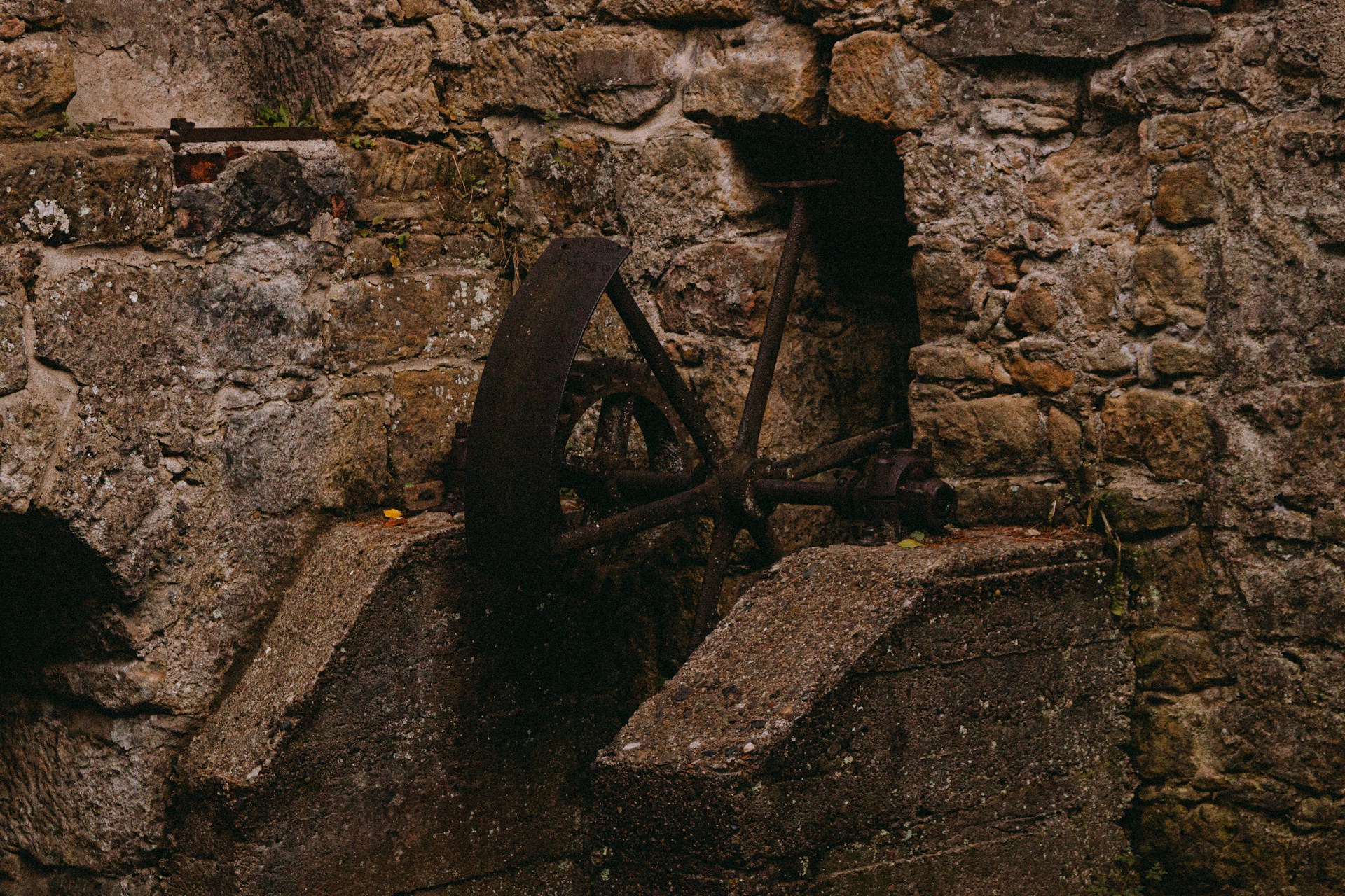 A stone wall with a water wheel on it