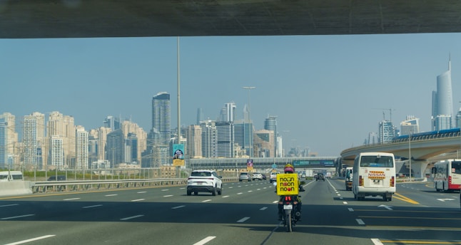 A man riding a bike down a street next to tall buildings