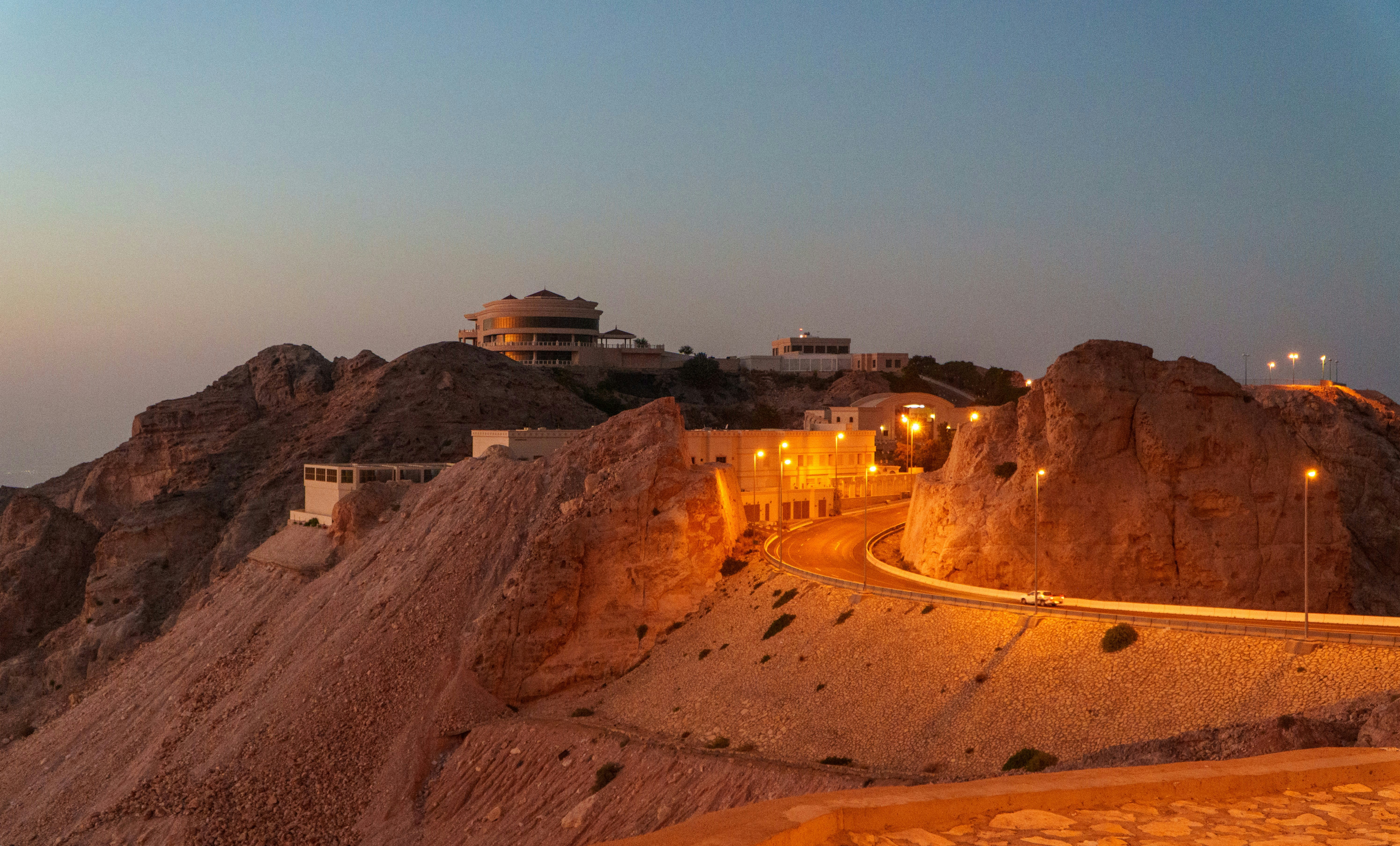A road going up a hill in the middle of a desert
