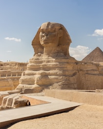 The sphinx and pyramids of giza are in the background