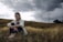 A woman sitting in a field of tall grass