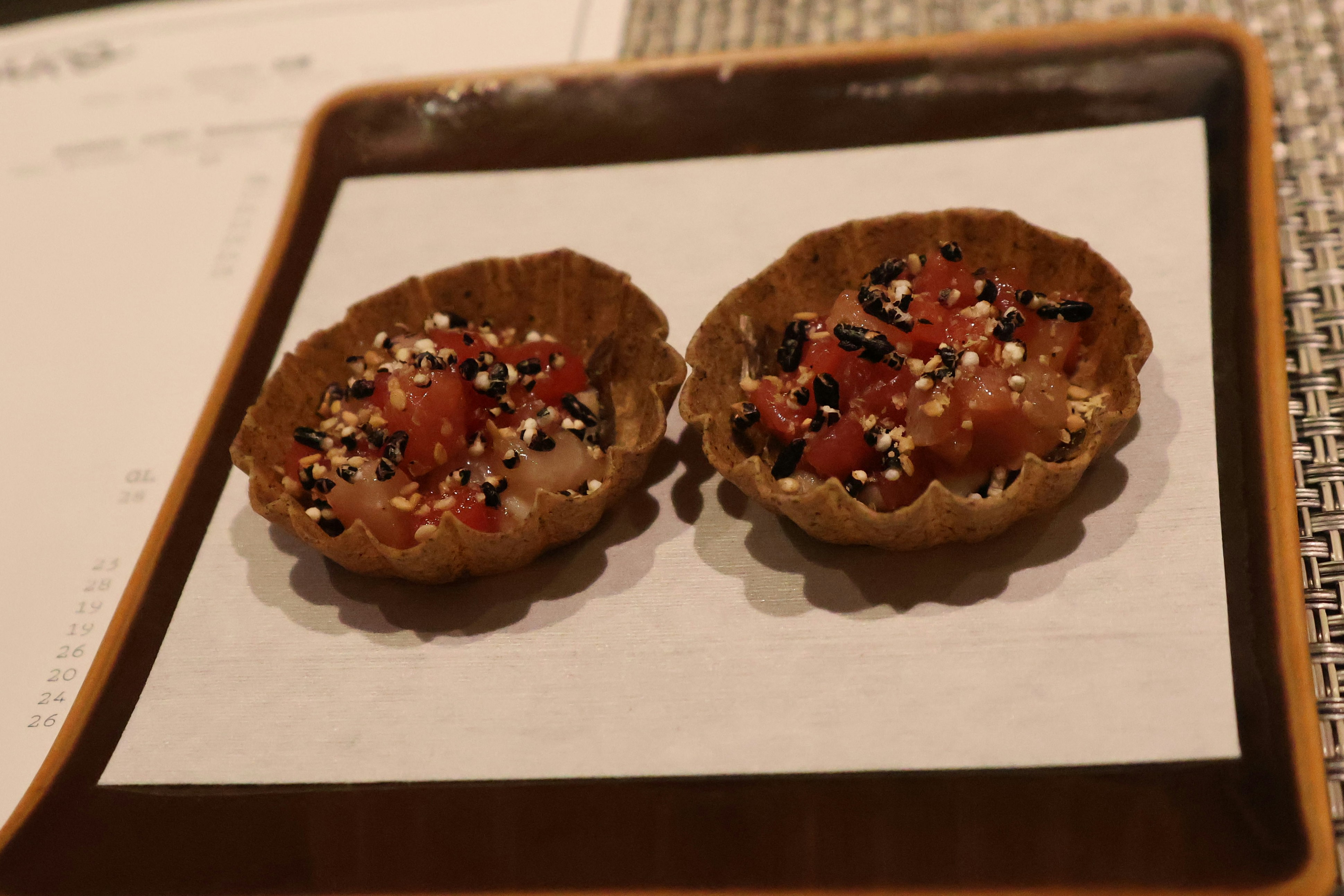 Two small pastries sitting on top of a wooden tray