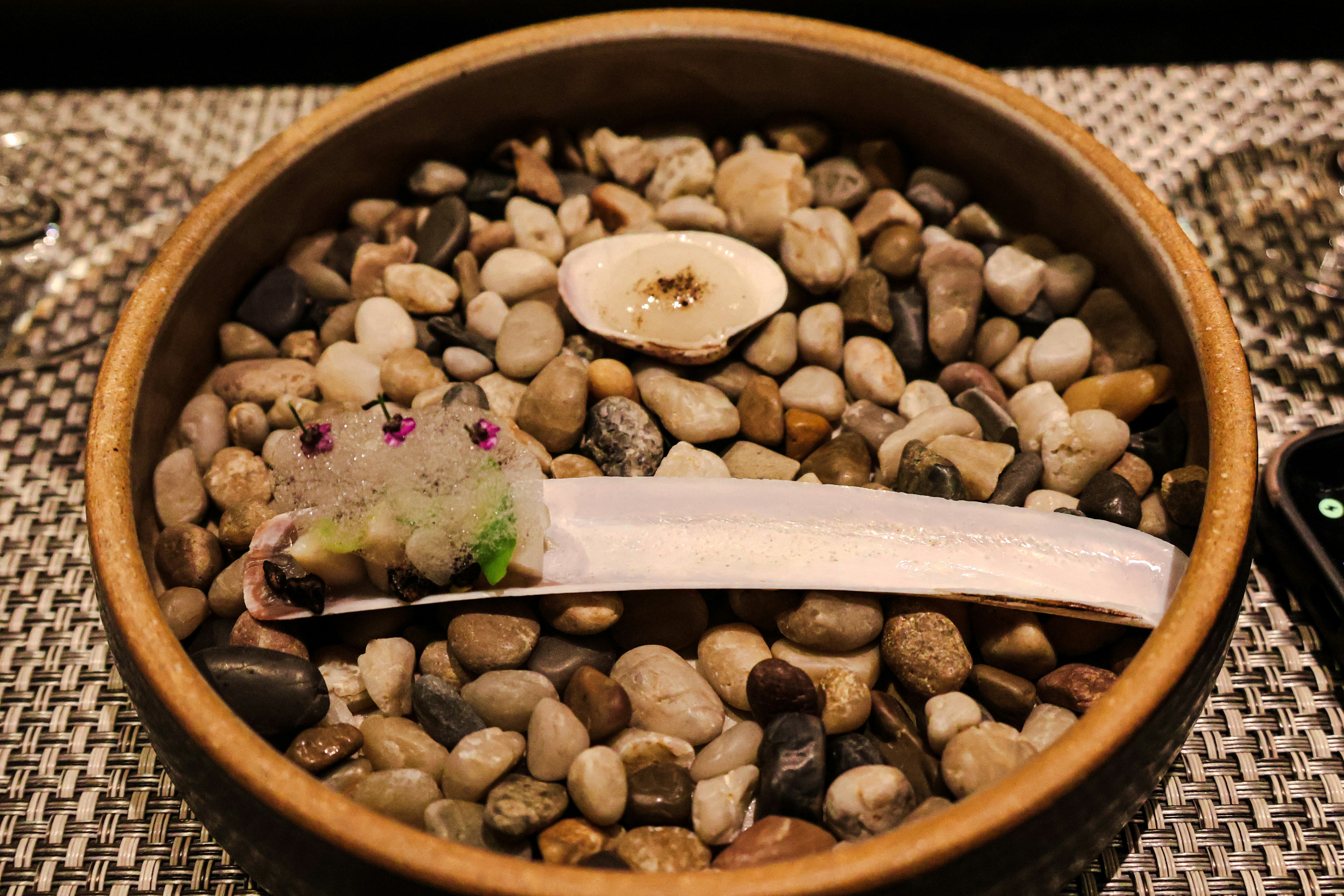 A wooden bowl filled with rocks and a banana