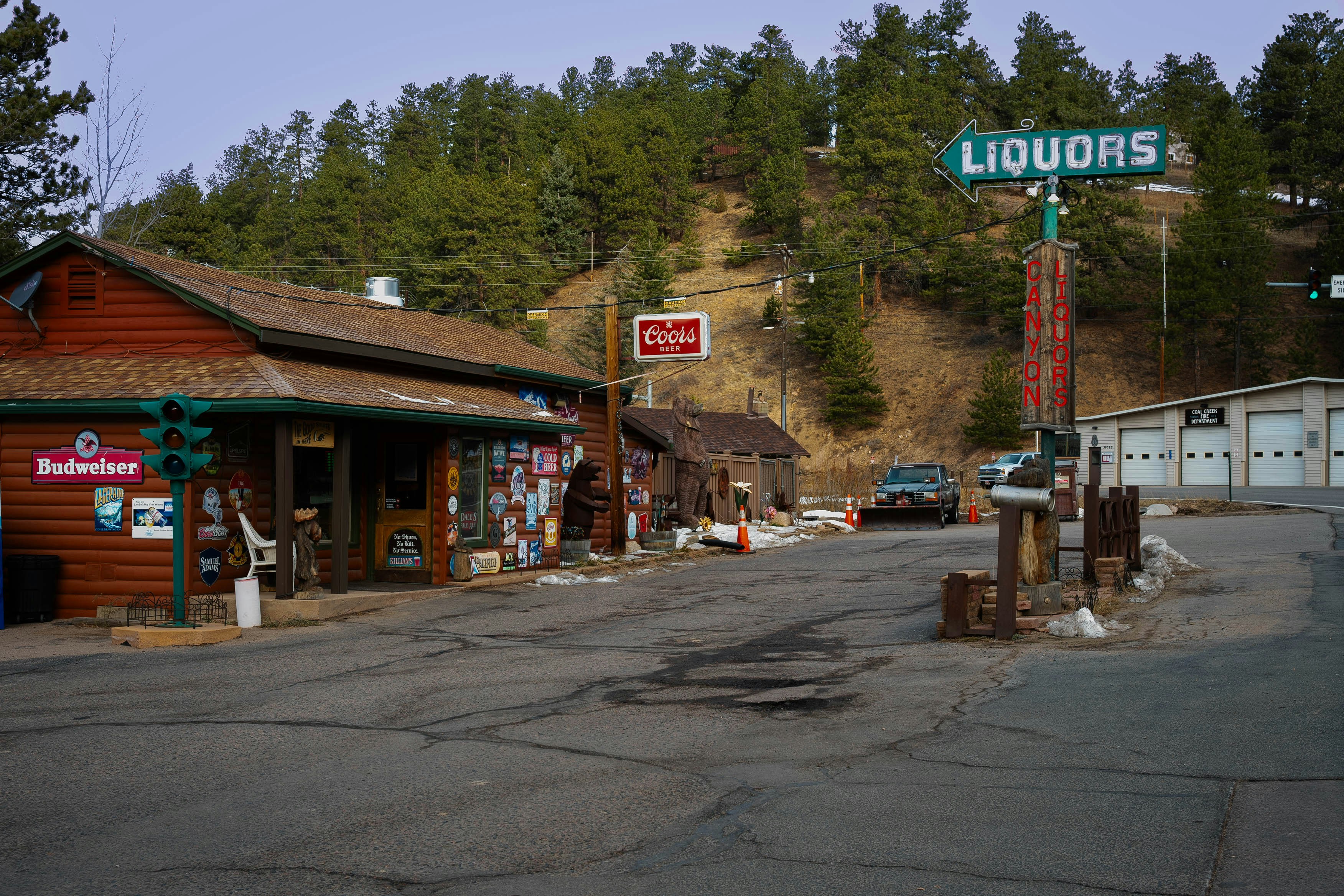 A street view of a liquor store with a mountain in the background