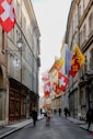 People walking down a street lined with flags