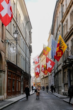 People walking down a street lined with flags