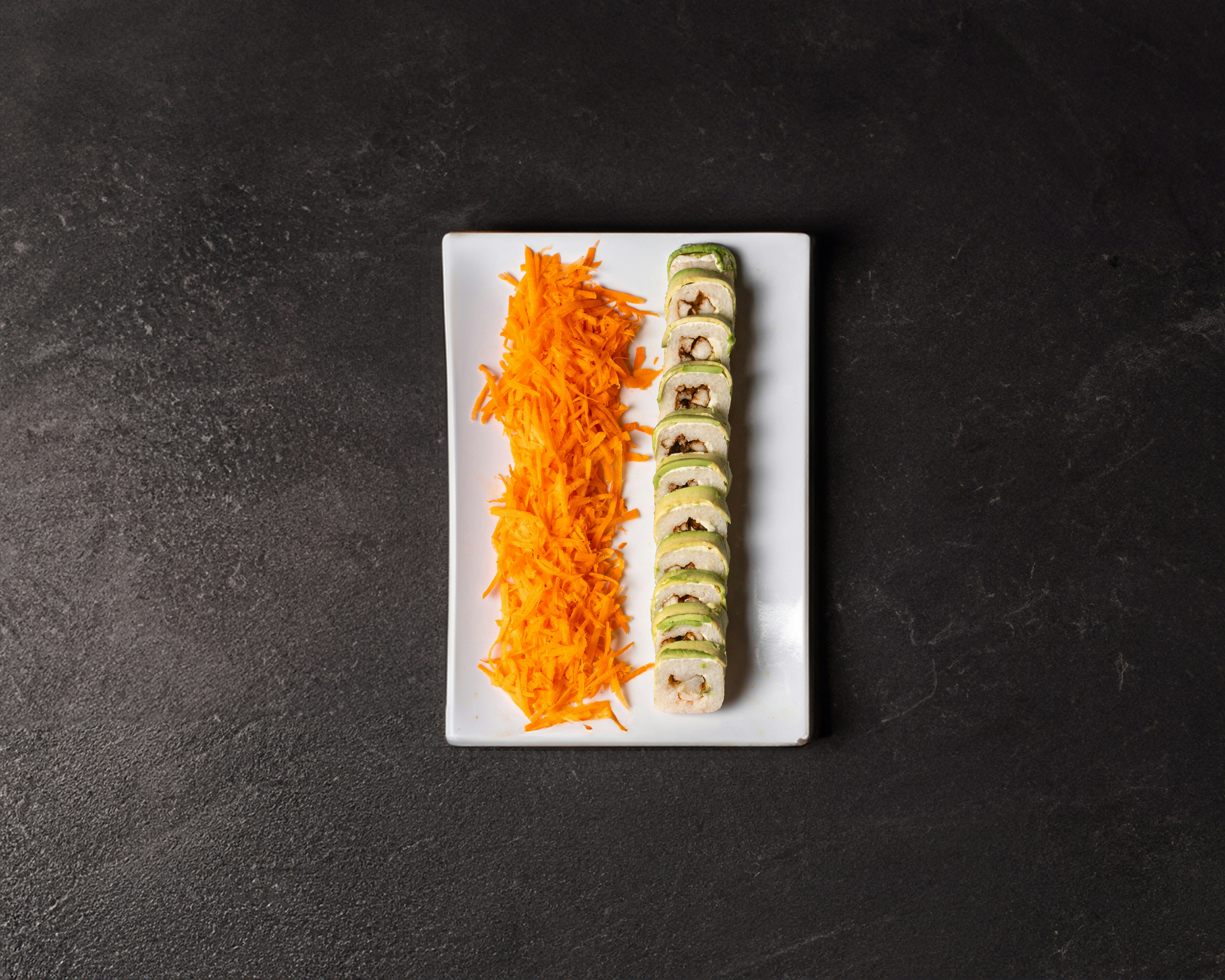 A white plate topped with two slices of sushi