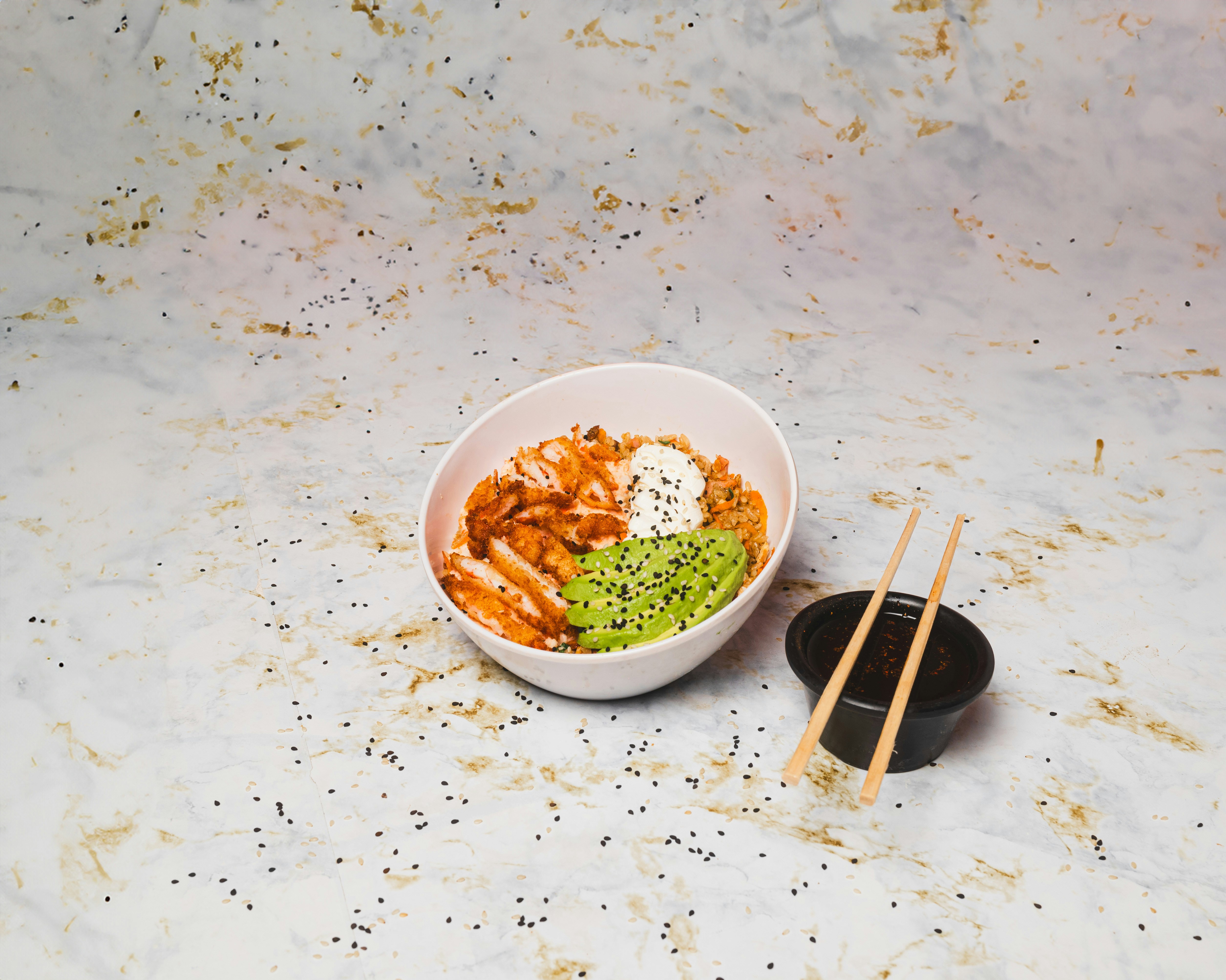 A bowl of food with chopsticks next to it