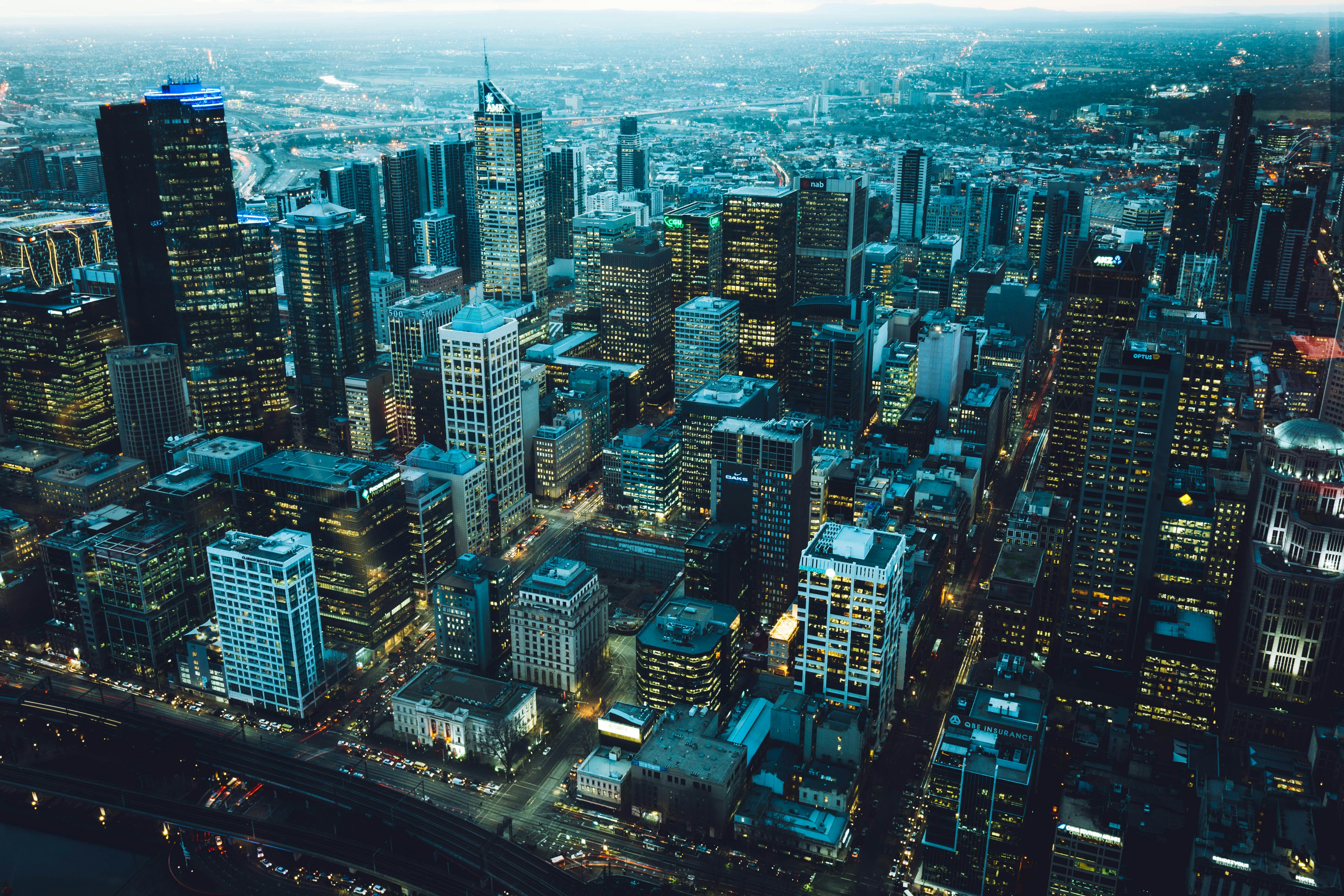Aerial view of a modern city skyline at dusk with glowing lights