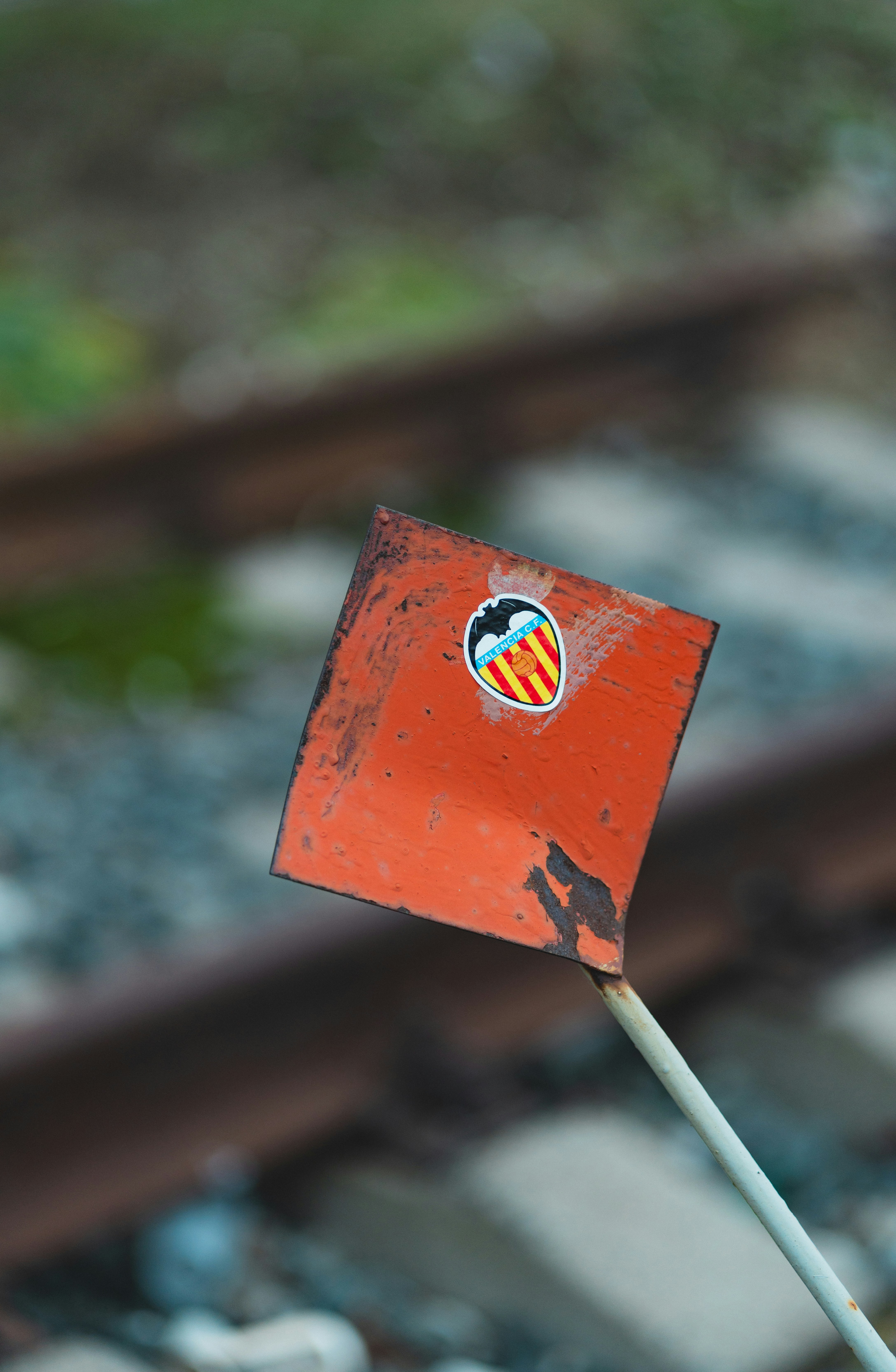 A red flag sticking out of the side of a train track