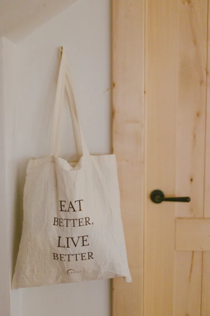 A tote bag hanging on a wall next to a door