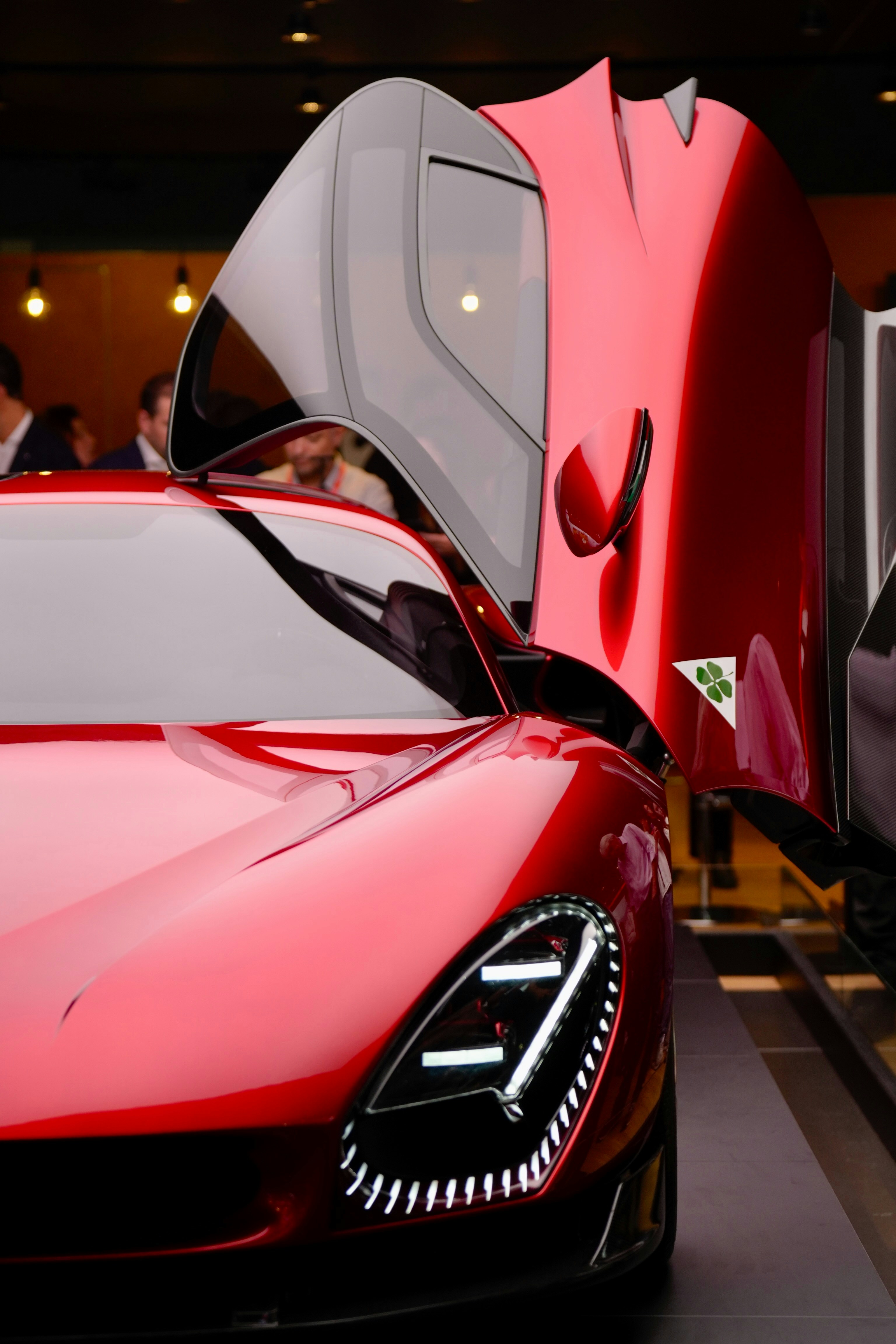 A red sports car parked next to a train