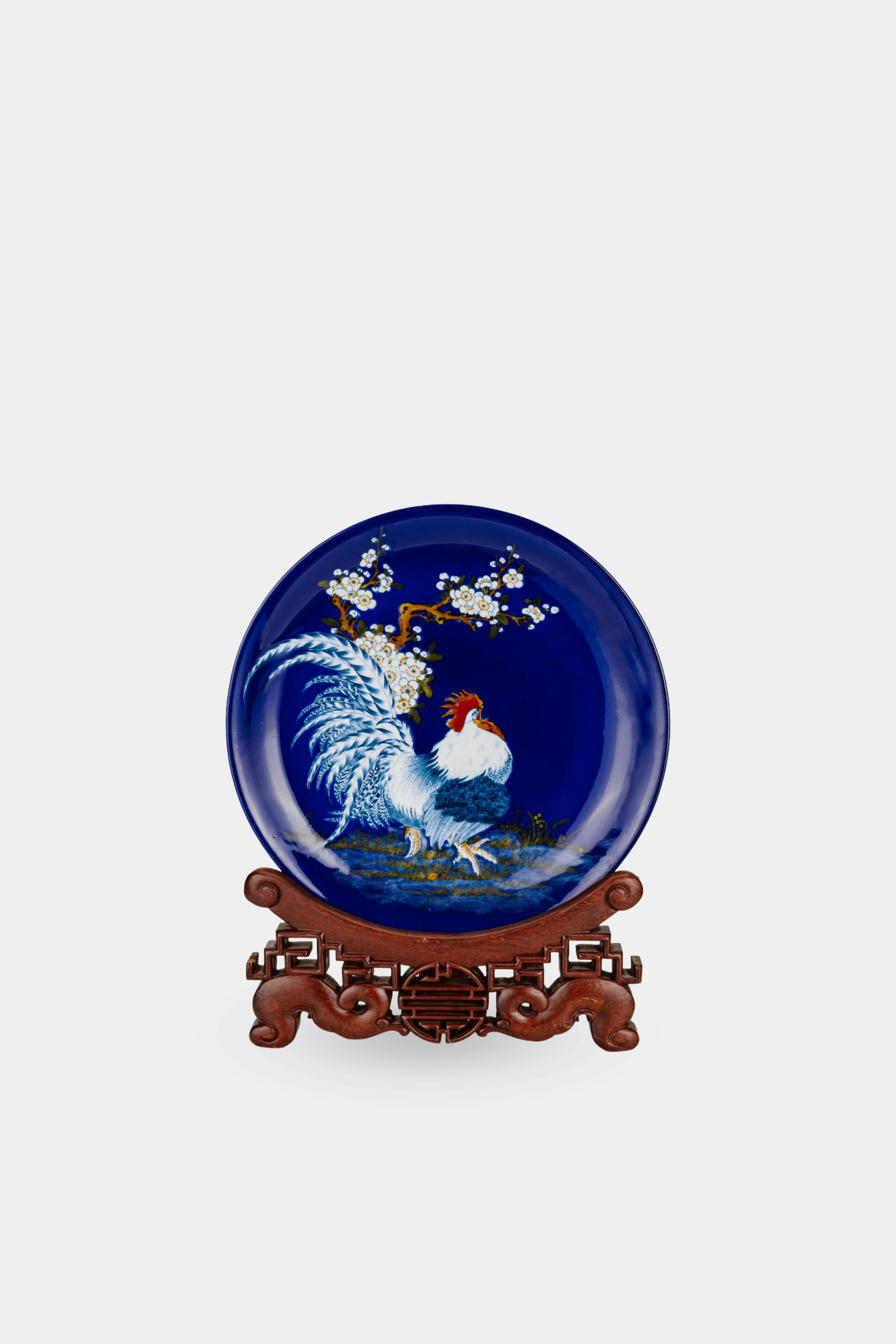 A blue plate with a rooster on it