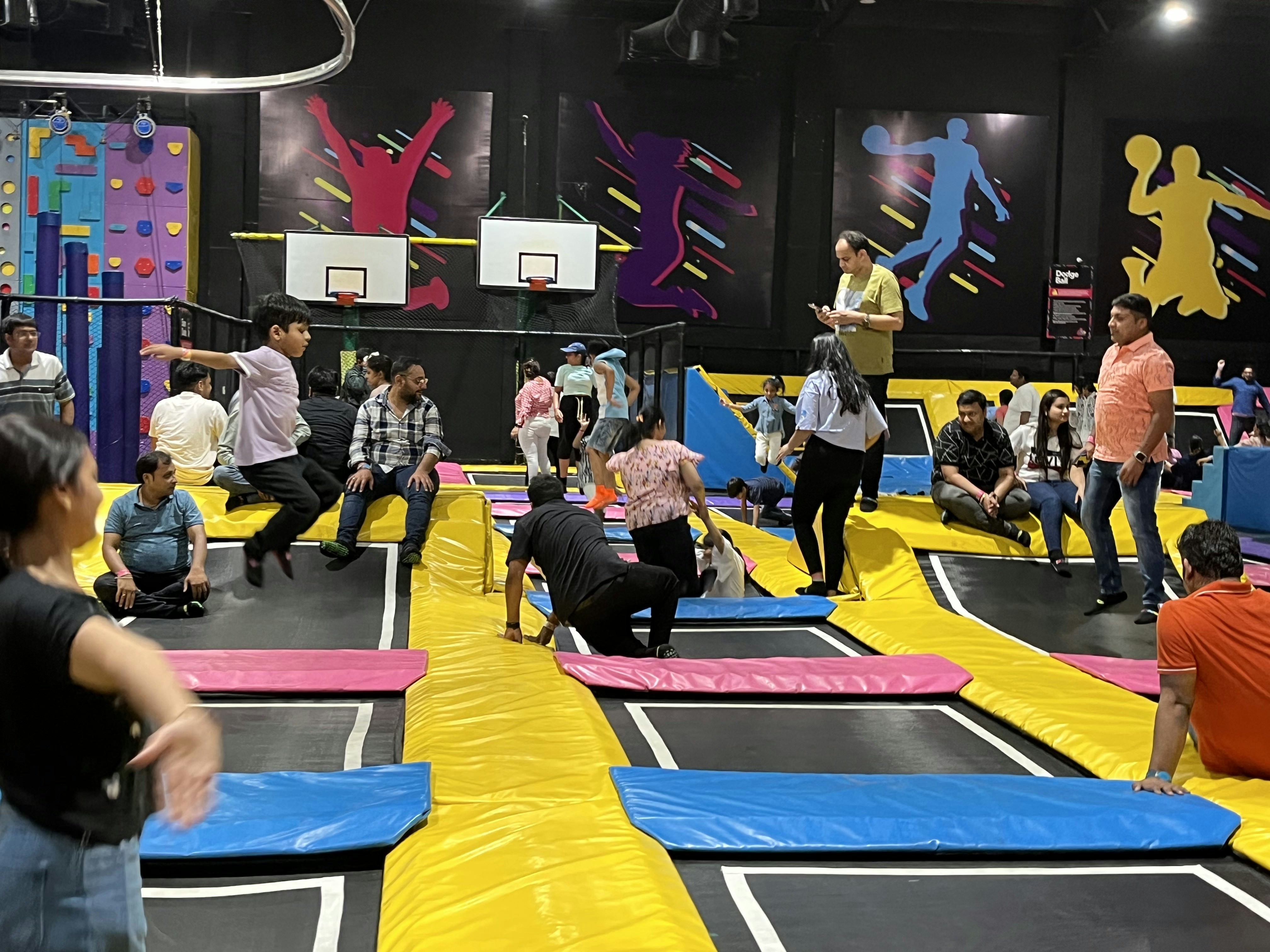 Indoor trampoline park with interconnected trampolines and safety nets overhead