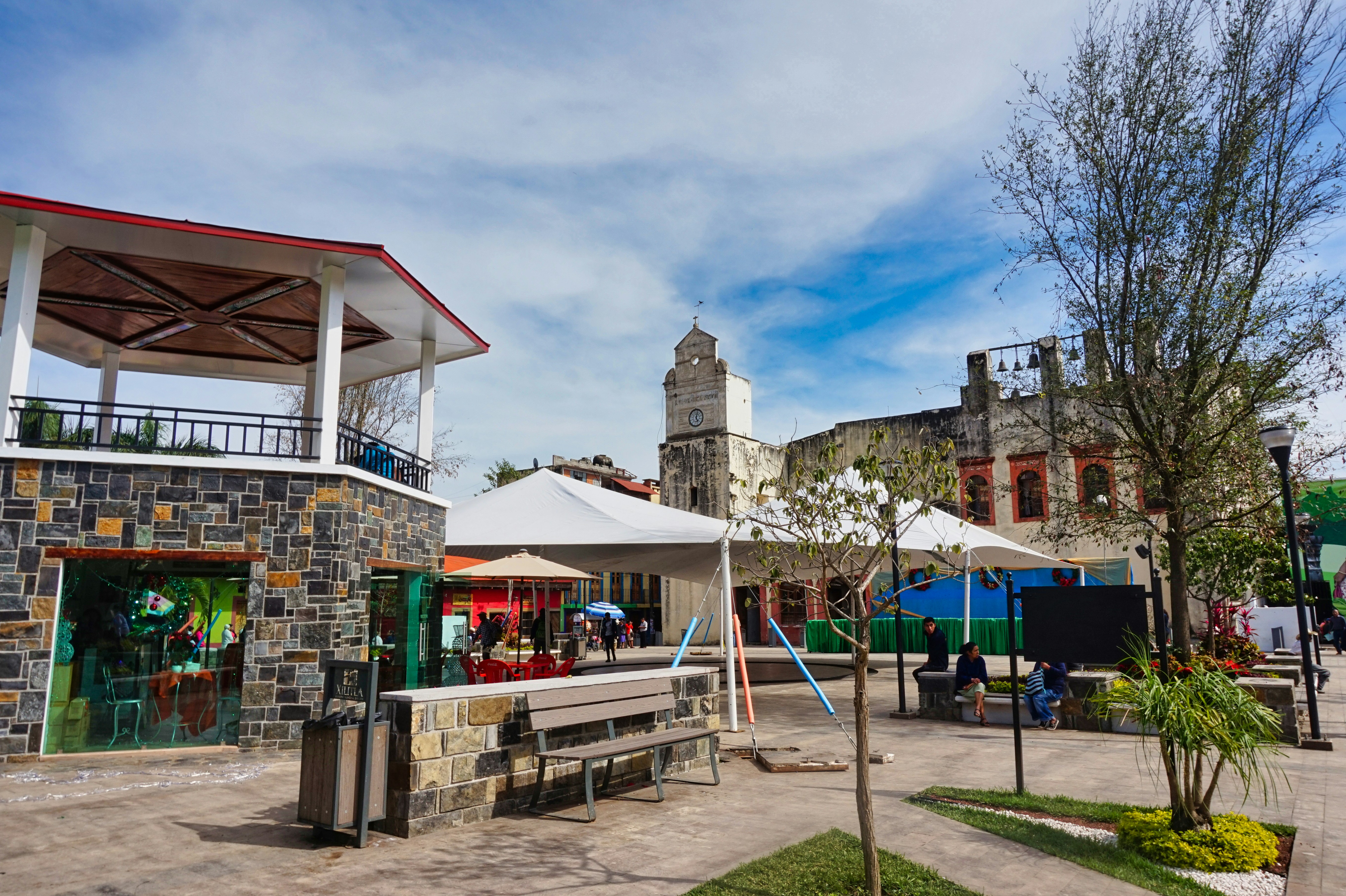 A group of people sitting at tables under umbrellas