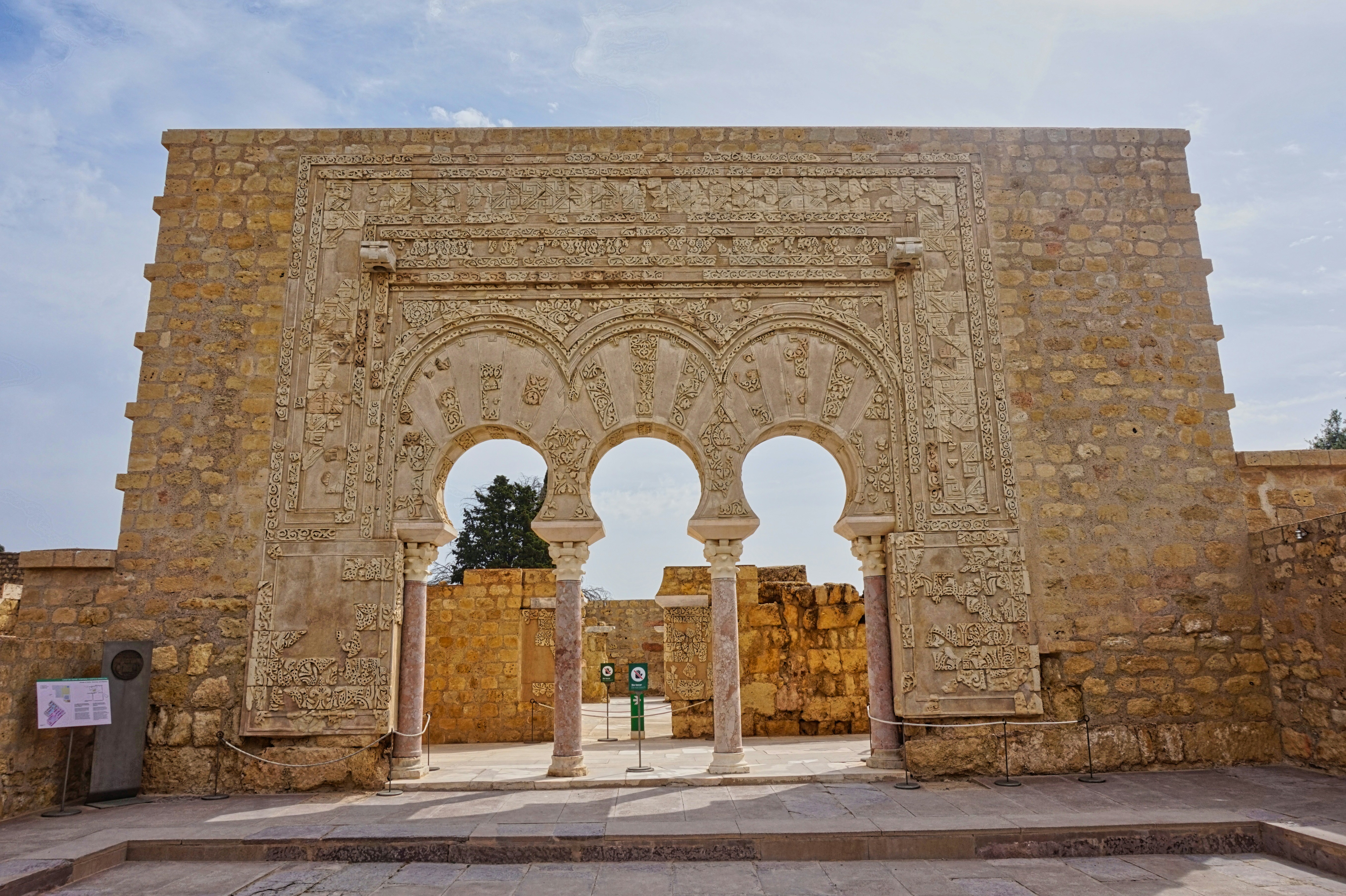 A stone building with arches and a statue