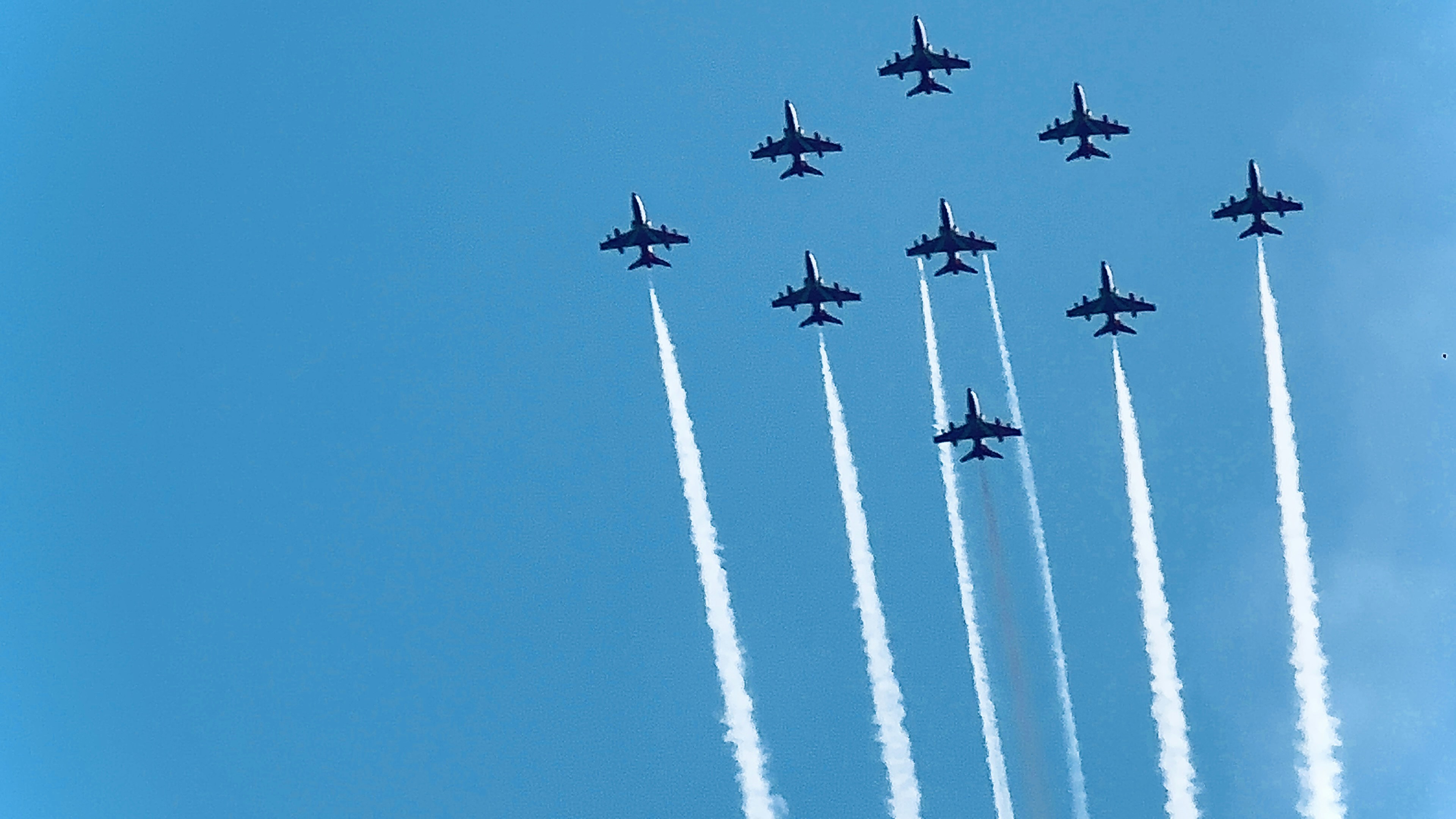 A group of fighter jets flying through a blue sky