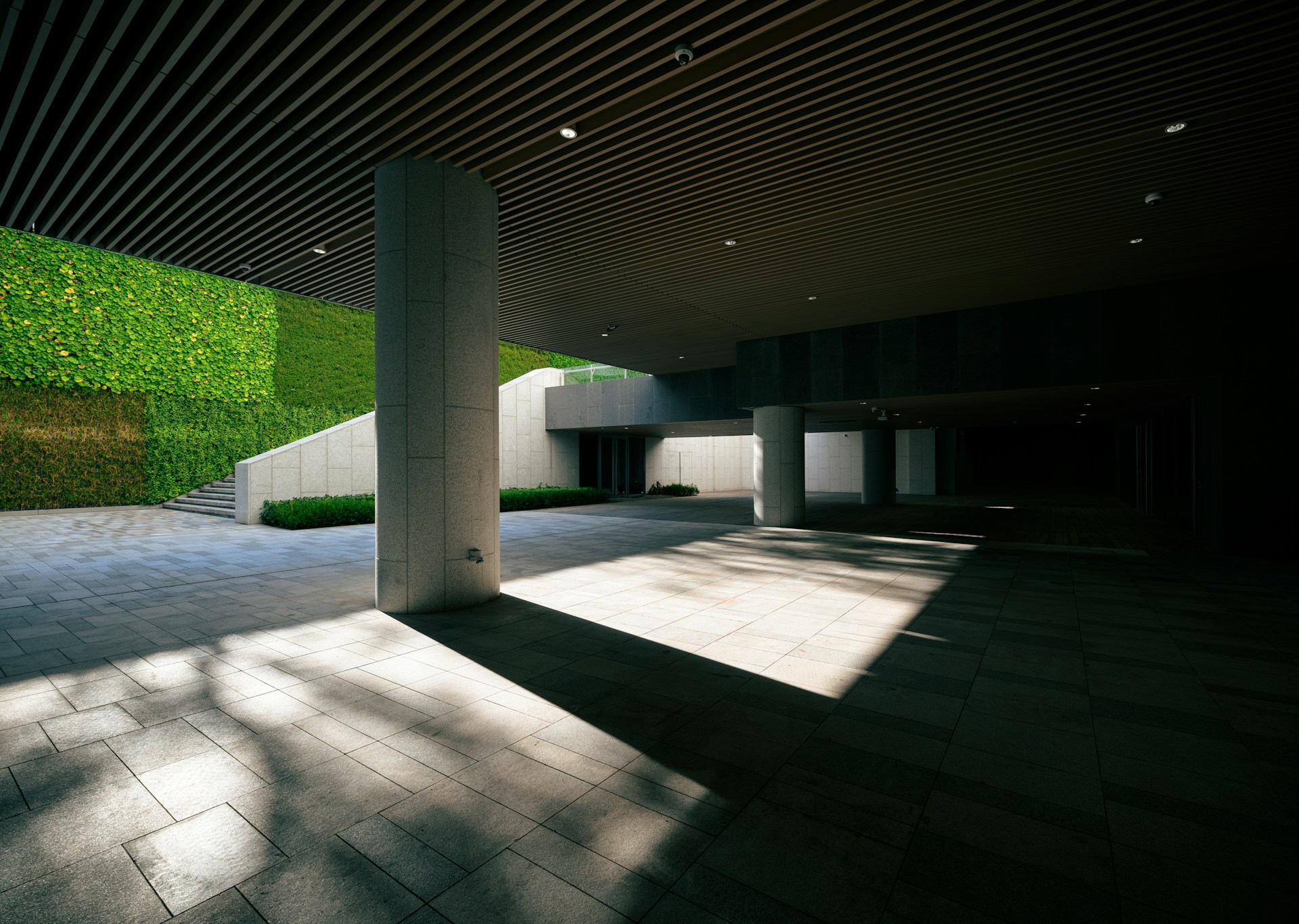 A room with a grass wall and a large window