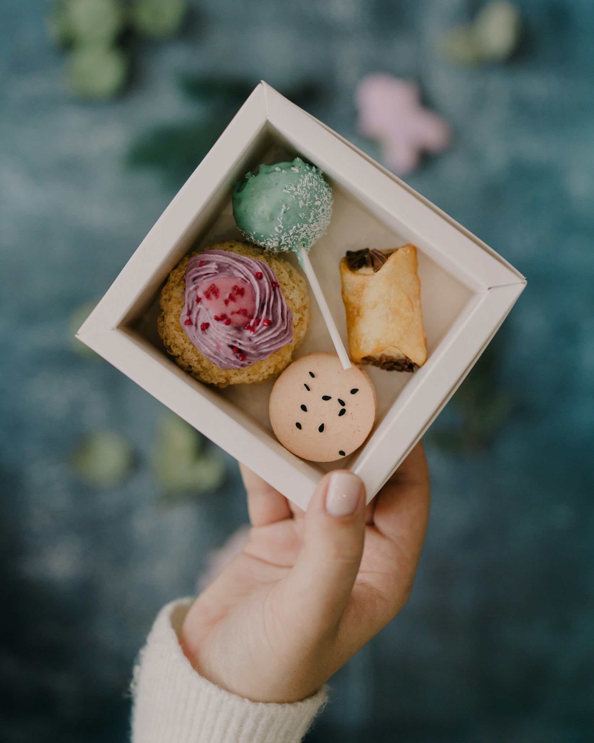 A person holding a small box of food