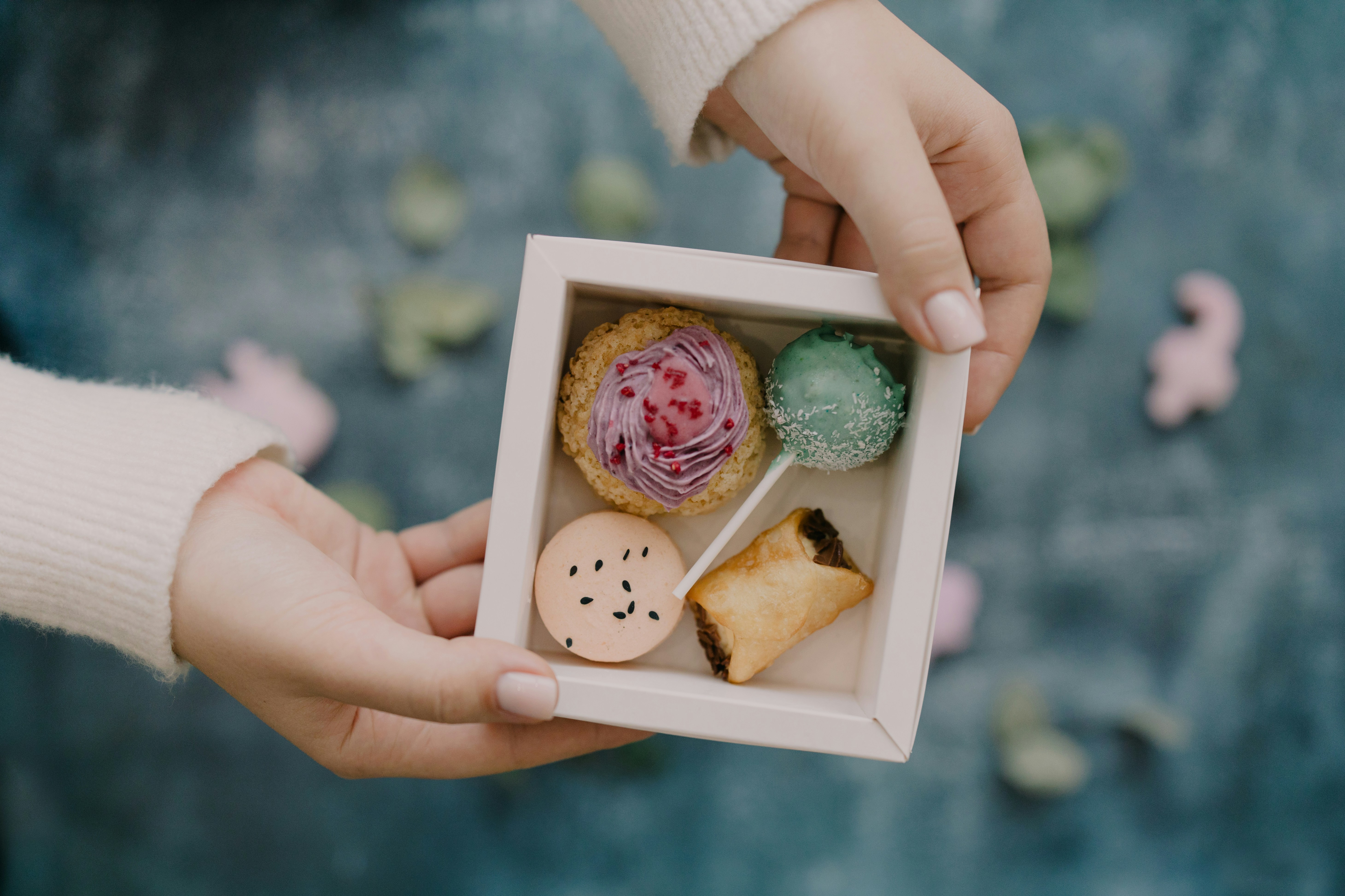 A person holding a small box of food