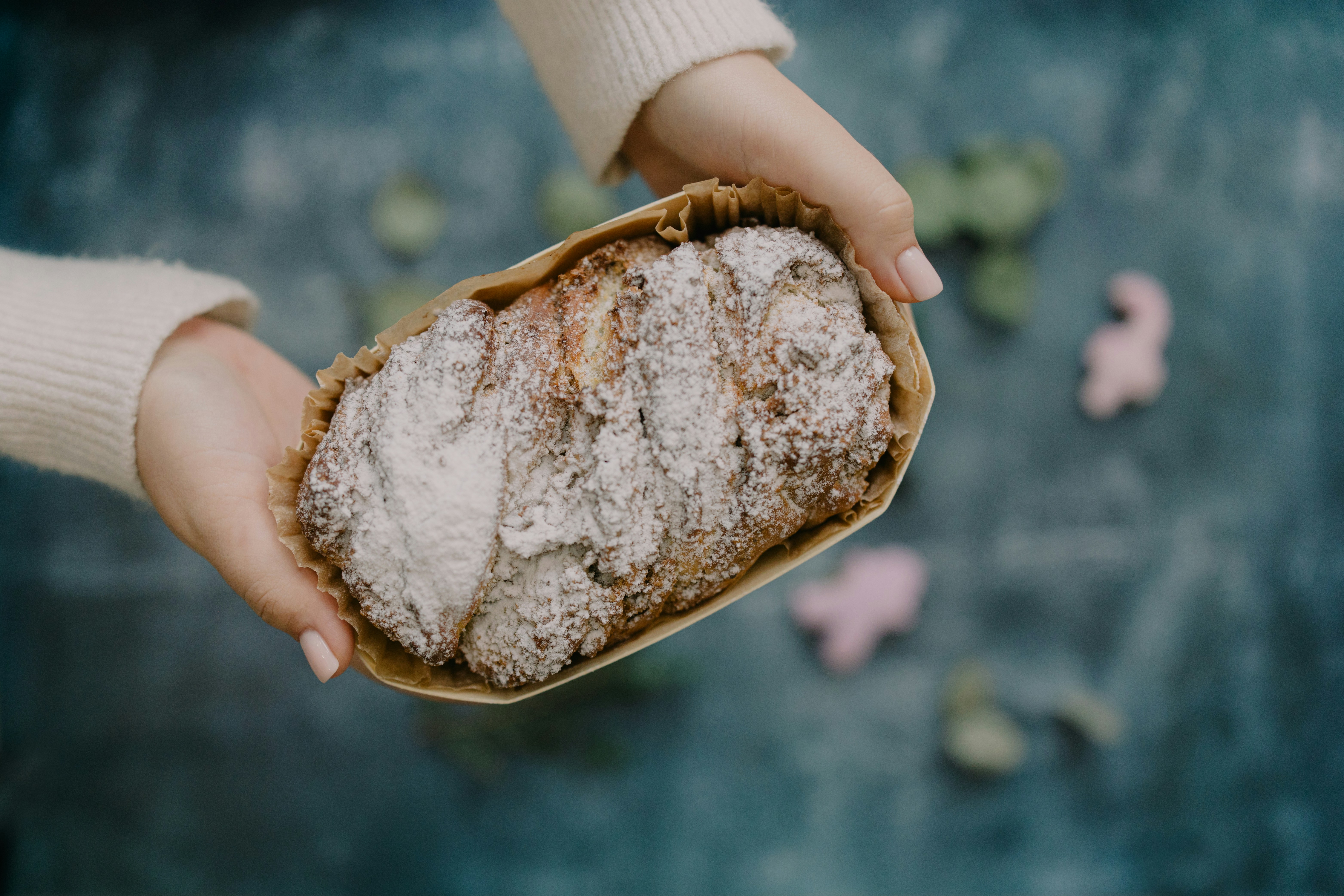 A person holding a loaf of bread in their hands