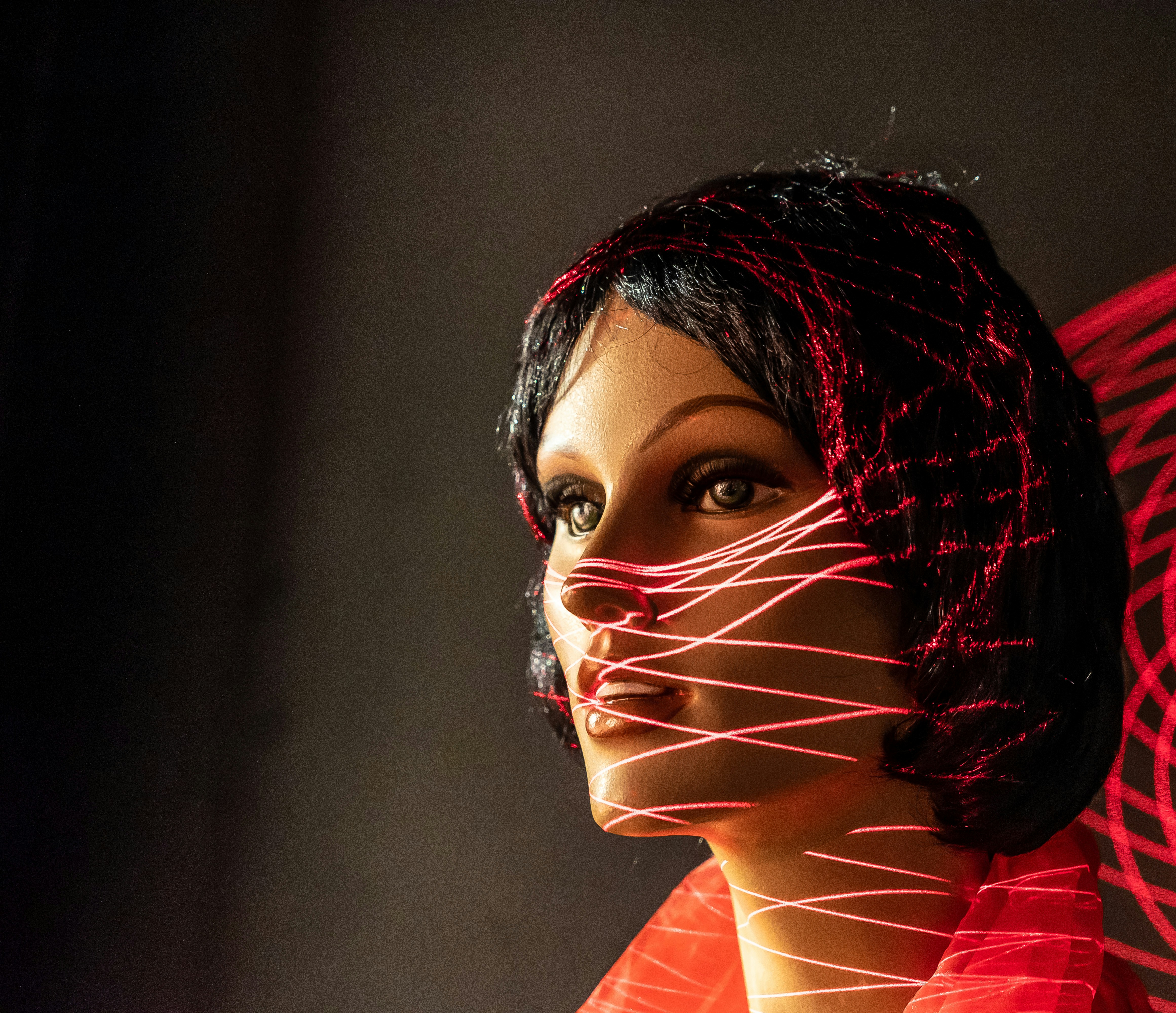 Eine Schaufensterpuppe in einem roten Kleid mit weißen Linien darauf