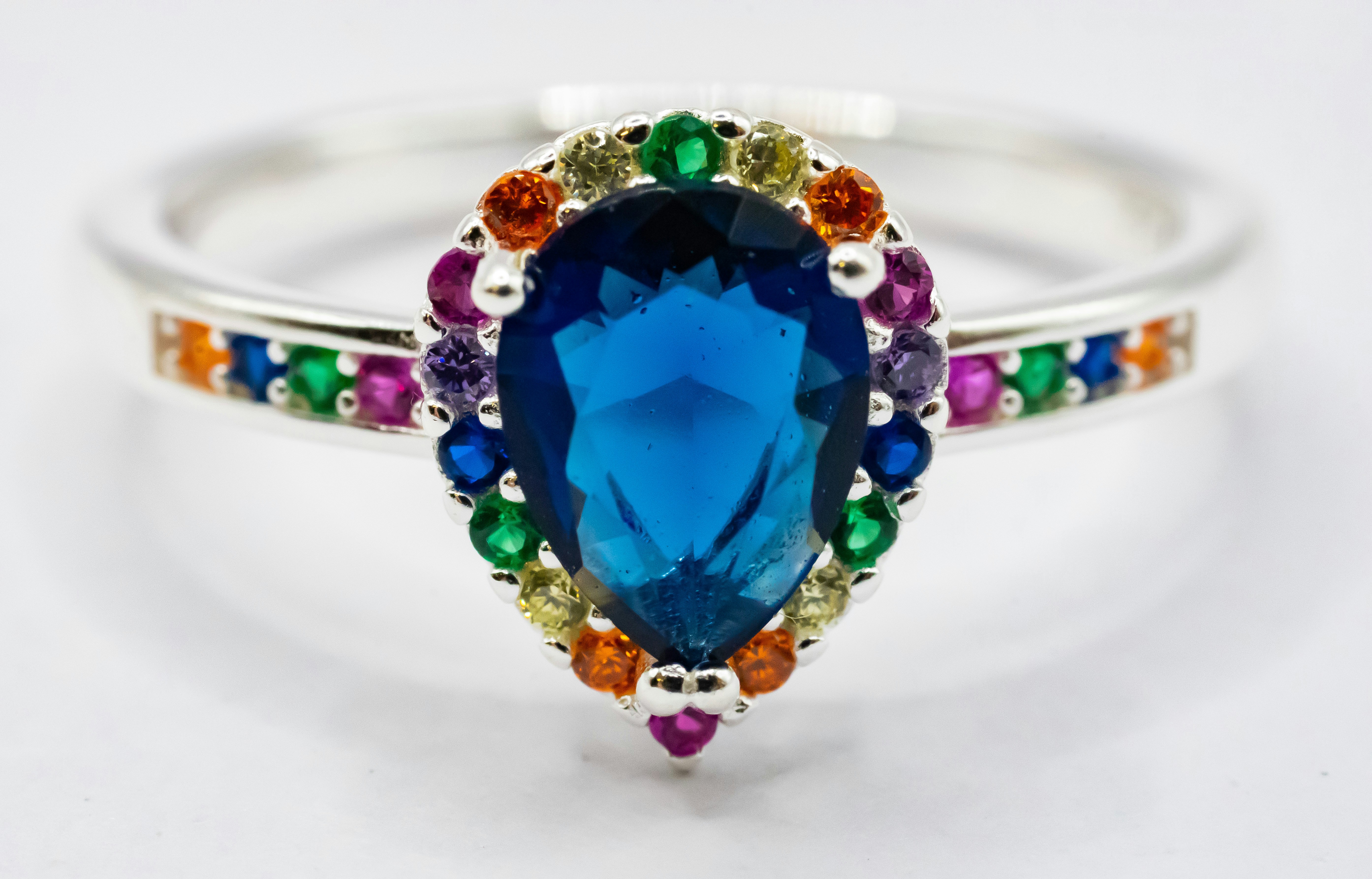 Ein Ring mit einem blauen Stein, umgeben von mehrfarbigen Steinen