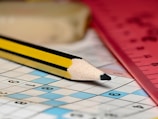 A pencil sitting on top of a crossword puzzle
