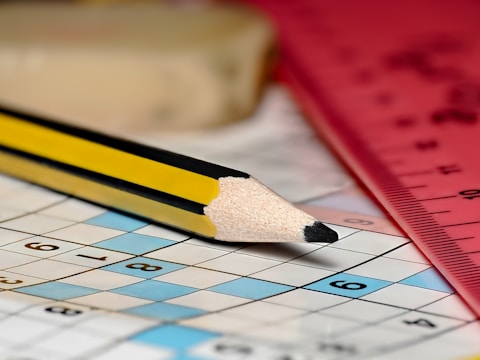 A pencil sitting on top of a crossword puzzle
