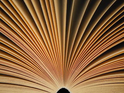 A close up of an open book with a black background