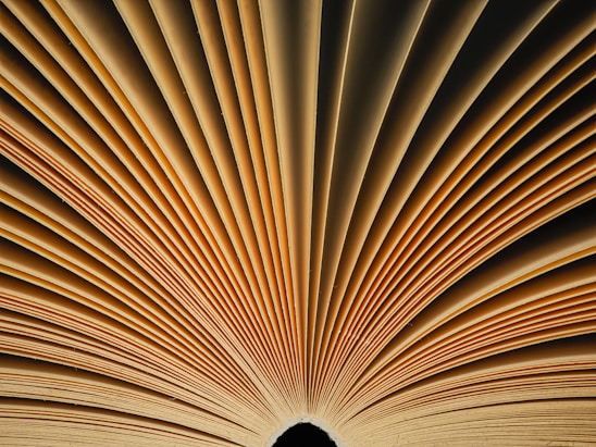 A close up of an open book with a black background