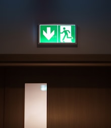 A green exit sign above a white door