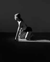A woman in a black and white photo kneeling down