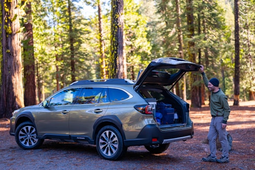A man standing next to a car with its trunk open