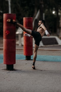 A man doing a kickbox kick in a park